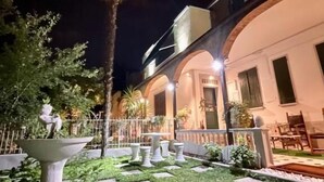 A well-lit courtyard with a fountain, stone planters, and a seating area. - Wagon-lit (Bologna)