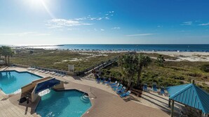 A resort pool area with multiple swimming pools, sun loungers, and a beach view. - Phoenix East 203 – Gulf-front with pool views & resort amenities (Orange Beach)