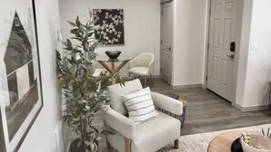 A modern living room with a white armchair, a side table, and a potted plant. - Stay in Boise’s coveted North End! This 3BR/2BA retreat  with Hot Tub and Walking distance to Hyde Park  and Camel’s Back Park close to Boise White Water park. E Bikes For Rent (Boise)