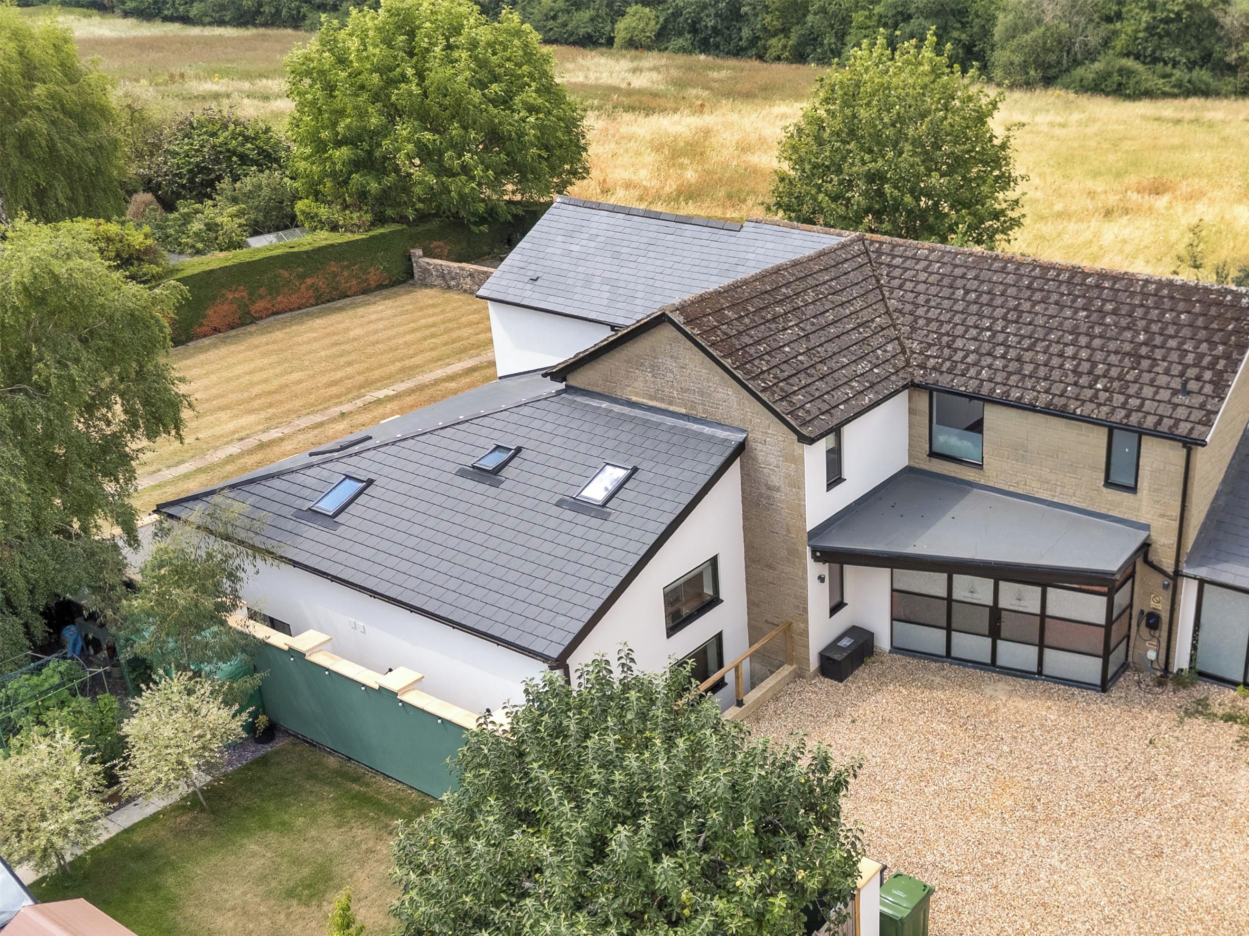 A residential property with a sloped roof, multiple windows, and a garage.