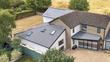 A residential property with a sloped roof, multiple windows, and a garage.