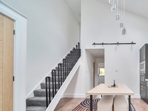 A modern interior with a staircase, a dining area, and a kitchen.