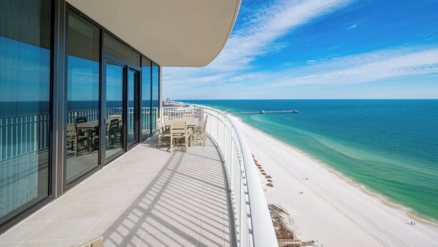 Un balcon avec vue sur une plage et l’océan.