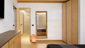 Een slaapkamer met een houten plafond, een bed, een nachtkastje en een bedtafel.