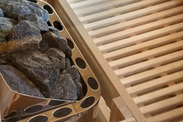 A metal tray with rocks, a wooden slatted surface, and a metal utensil.