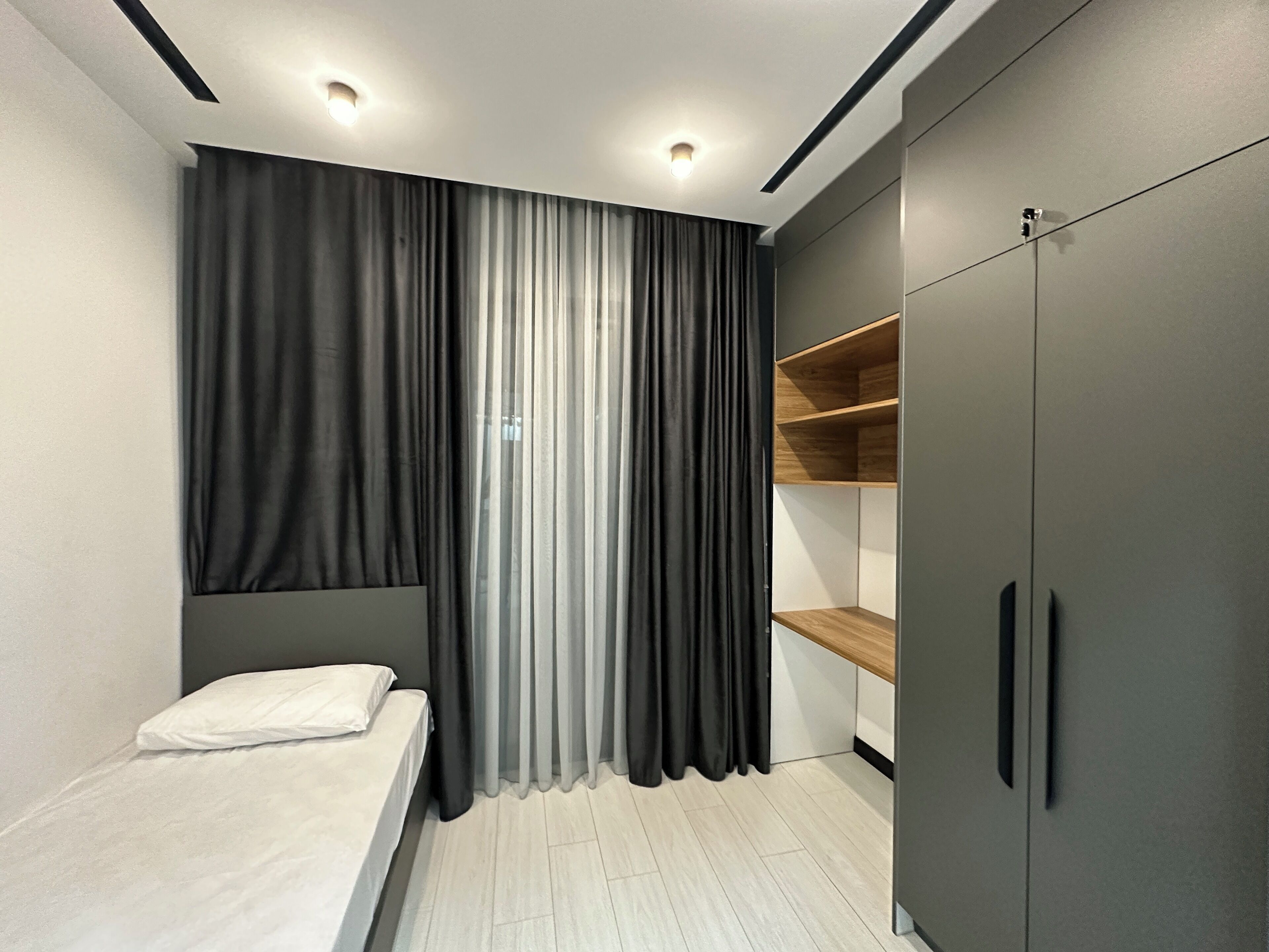 Ein Schlafzimmer mit einem Bett, einem Kleiderschrank und einer eingebauten Regallösung.