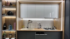 Une cuisine moderne équipée d’un évier intégré, d’une machine à café et d’une cuisinière à gaz.