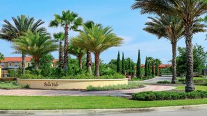 A landscaped area with palm trees and a circular planter labeled "Bella Vida." - Bella Vida Cozy Home | 15 min to Disney | Resort Style (Kissimmee)