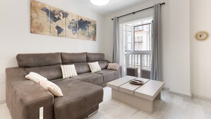A modern living room with a sofa, a coffee table, and a world map artwork on the wall. - 'Apartamento Mariblanca 6' with Balcony, Wi-Fi and Air Conditioning (Málaga)