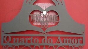 A decorative sign with the words "Welcome" and "Quarto do Amor" on a red background. - Macarena AL (Almada)