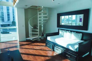 Ein Schlafzimmer mit einem Bett, einem großen Fenster, einer Treppe und Blick nach draußen.