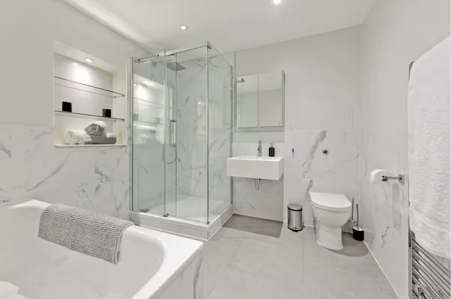 Une salle de bain moderne avec une douche à parois de verre, une baignoire sur pieds et des toilettes.