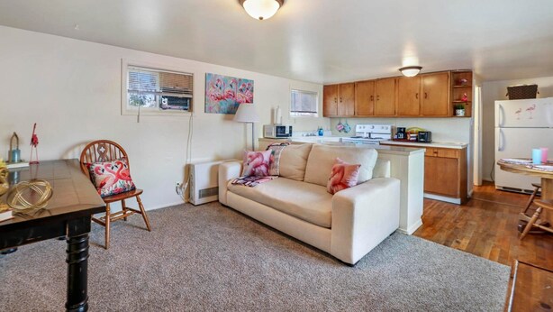 Un espacio habitable compacto con kitchenette, un sofá, una mesa de comedor y una silla.
