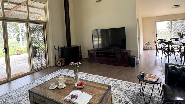 A spacious living room with a fireplace, a television, a coffee table, and a dining area.