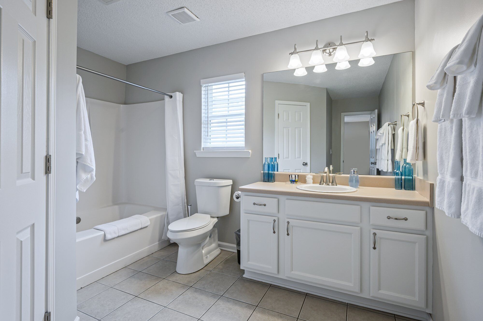 A bathroom with a toilet, sink, vanity, and shower area.