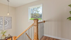 A wooden staircase with a view of trees outside a window. - 27 West Ridge Drive SE, Cartersville (Cartersville)