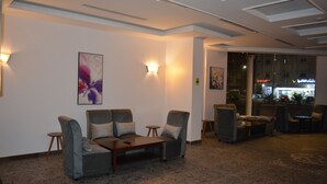 A lobby with sofas, a coffee table, and wall-mounted lights. - فندق مرسى القصر Marsa Alqaser Hotel (Madinah)