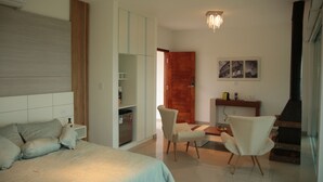 A modern bedroom with a large bed, a wardrobe, a desk, and a chair. - Unique Alta Vista Pousada Boutique (Córrego do Bom Jesus)