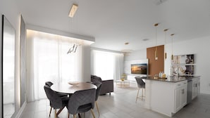 A modern kitchen with a central island, white cabinetry, and pendant lighting. - Storey Lake Resort 4BR Home w/ Private Pool (Kissimmee)