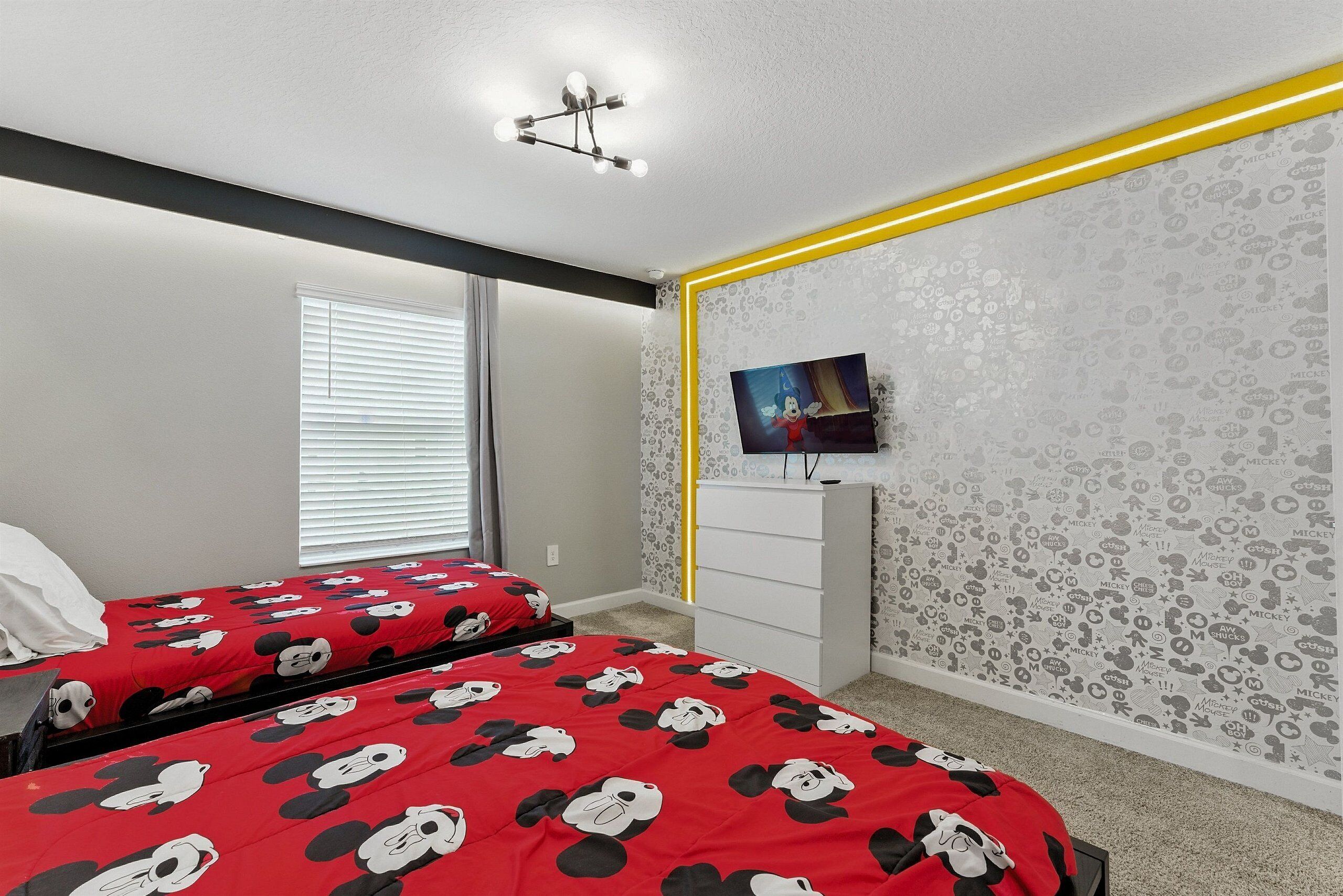 A bedroom with two beds, a TV, and a dresser.