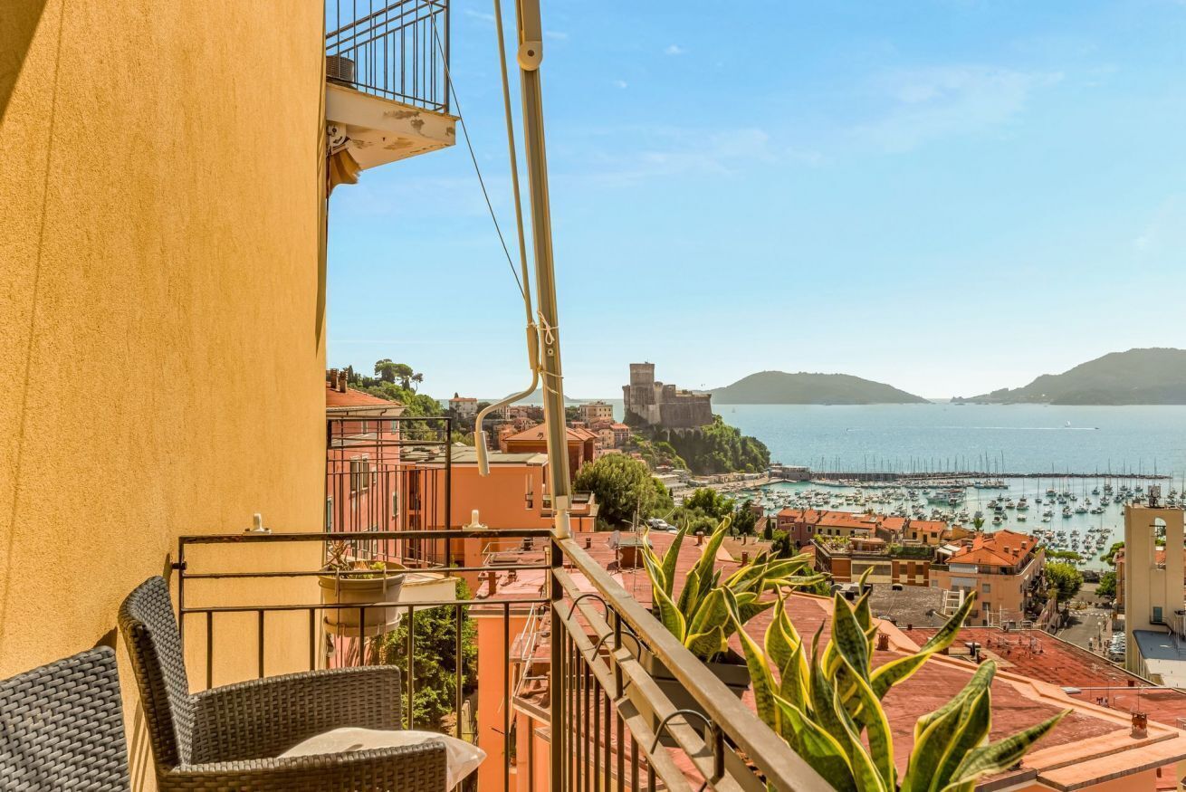 A balcony with a view of a coastal town, including buildings and a marina.