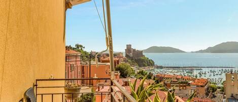 A balcony with a view of a coastal town, including buildings and a marina.