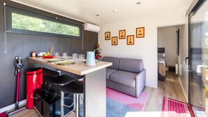 Um espaço compacto com cozinha americana, sofá e área de refeições.