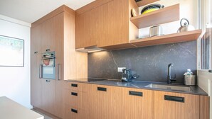 Una cocina moderna con armarios de madera, encimera negra y horno integrado.