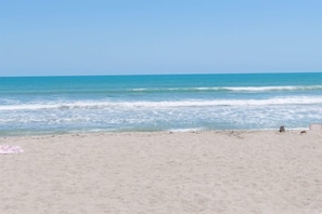 A beach with a clear sky and calm sea.