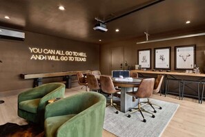 A modern meeting room with a large table, green upholstered chairs, a projector, and framed artwork on the wall. - Sleeps 12, Pool, Games, Fun, Mins from Downtown (Austin)