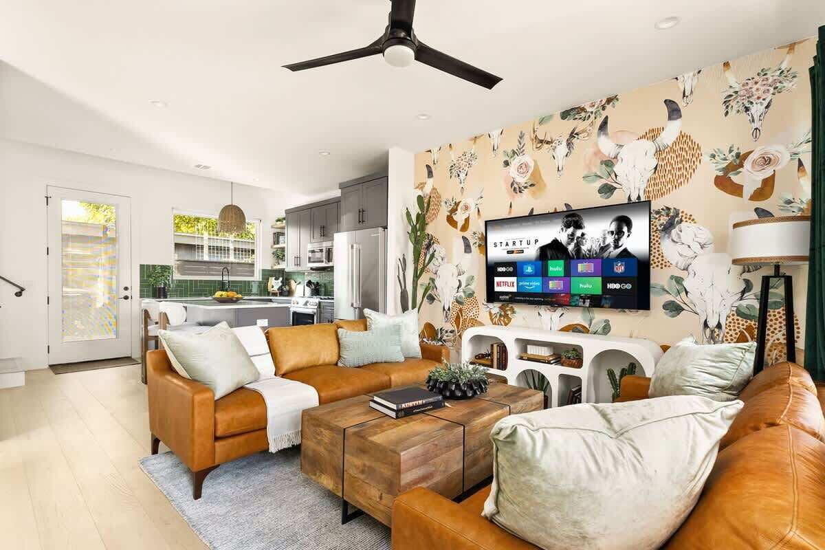 Un salon moderne avec un canapé, une table basse et un téléviseur fixé au mur.