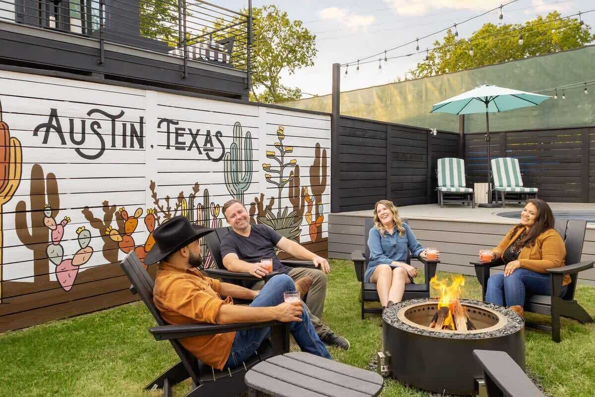 A patio area with a mural, outdoor seating, and a fire pit.