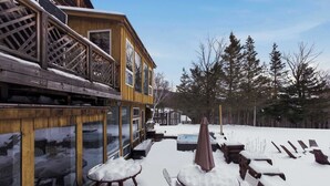 A wooden deck with outdoor seating and a snow-covered patio.