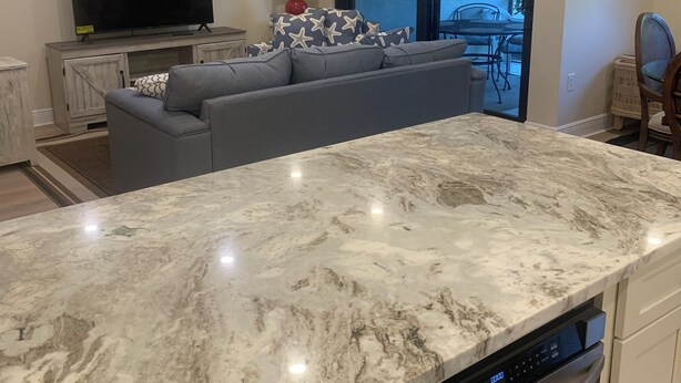A modern kitchen with a marble countertop, built-in dishwasher, and a large window overlooking a patio area. - ATTENTION GOLF LOVERS / HAMMOCK BAY GOLF COURSE, NAPLES FL./ CLOSE TO BEACHES (Naples)