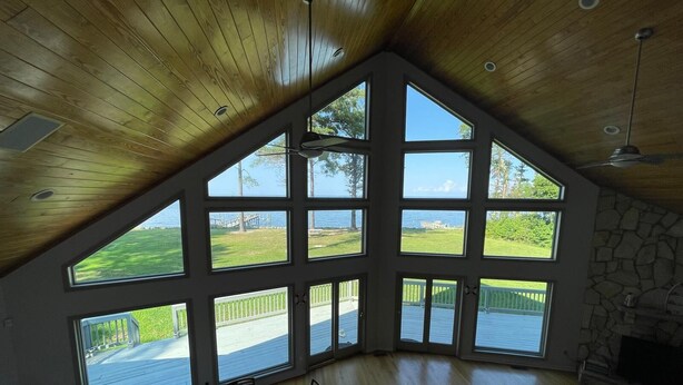 Una habitación amplia con techo alto, ventanas grandes, chimenea y un comedor.