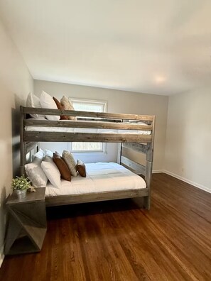 A bunk bed in a room with wooden flooring and a window. - The Shameless Cowboy: Stillwater, OK (Stillwater)