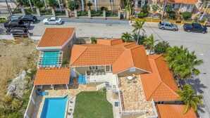 A residential property with a swimming pool, a patio, and a well-maintained lawn. - Private Pool! Rooftop with Ocean View! (Savaneta)