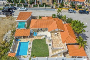 A residential property with a swimming pool, a patio, and a well-maintained lawn.