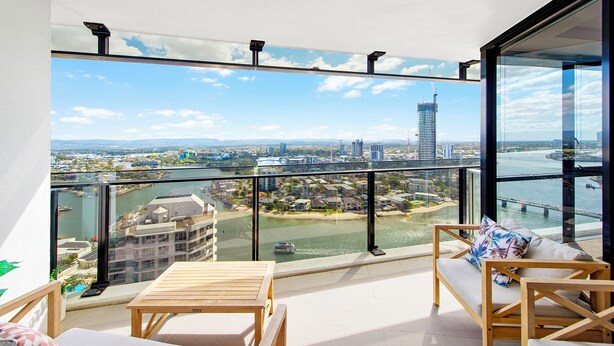 A balcony with a view of a river, cityscape, and a tall building. - Circle on Cavill - Level 19 - Riverside (Surfers Paradise)