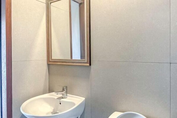 A bathroom with a white sink, a mirror, and a toilet. - Loft2s Chiang Mai (Chiang Mai)