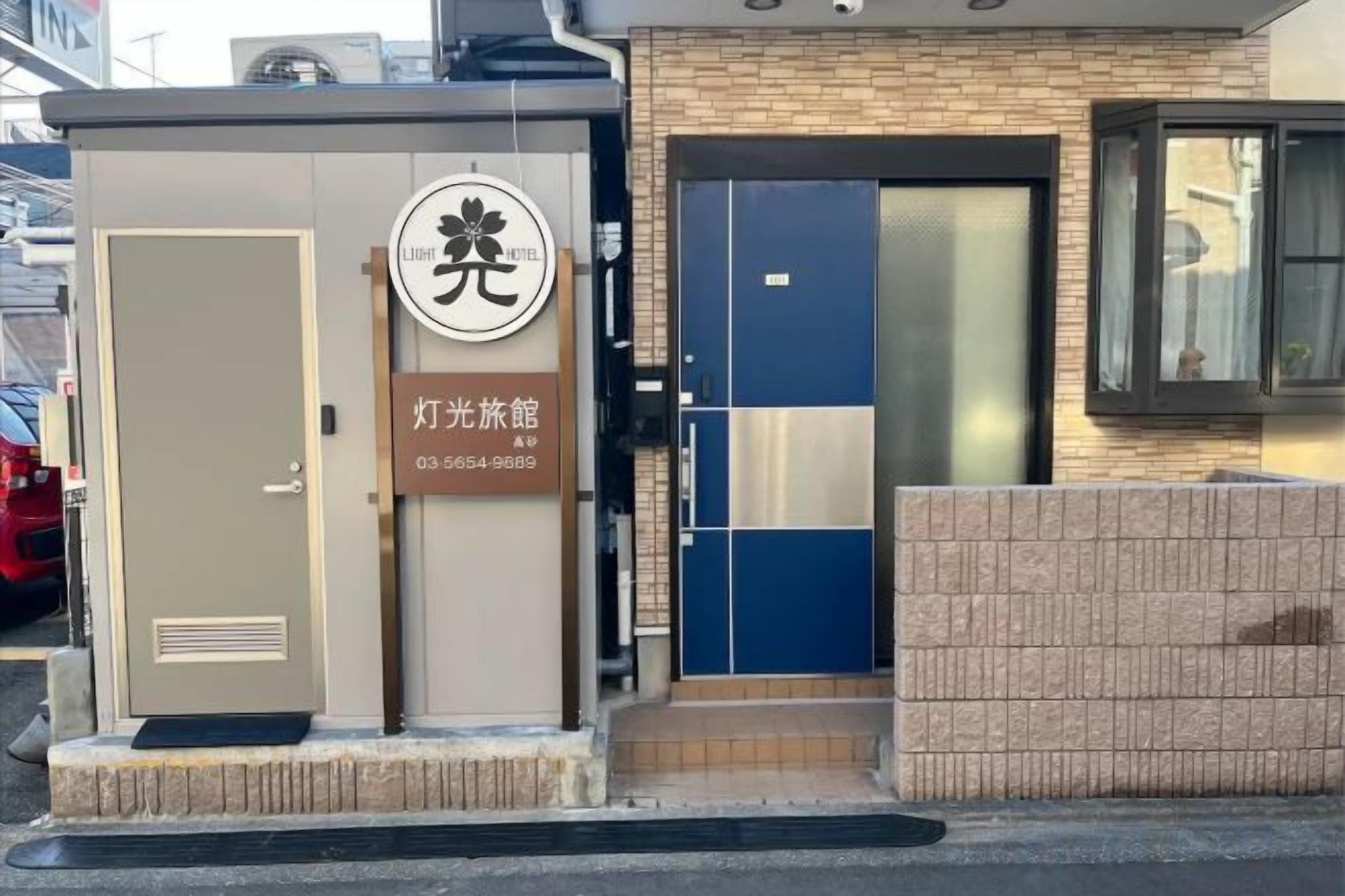 A building with a beige door, a blue door, and a window.