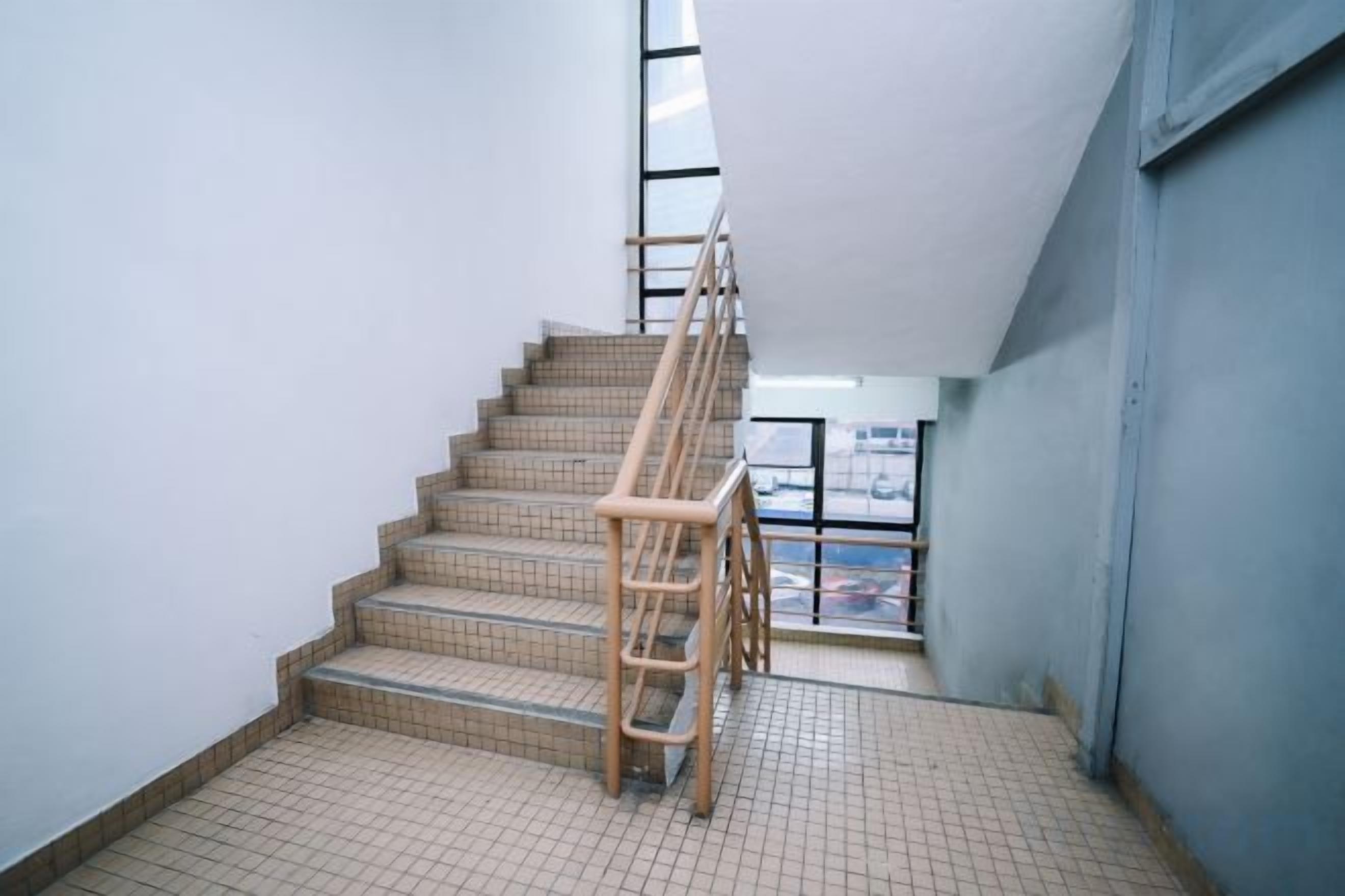 Una escalera con barandilla de madera que lleva a una plataforma.