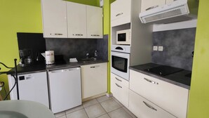 Eine moderne Küche mit weißen Schränken, einem Geschirrspüler, einer Mikrowelle und einem Backofen.