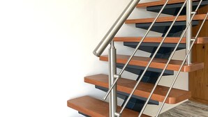 Un escalier moderne avec des marches en bois et des rampes en métal.