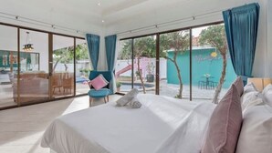 A hotel room with a large bed, a chair, and a view of the outside. - 3 beds Pratamnak Near Walking Street (Chon Buri)