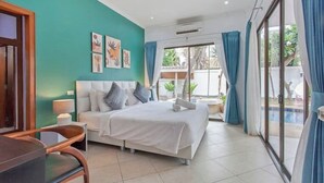 A modern hotel room with a bed, a desk, and a view of a swimming pool. - 3 beds Pratamnak Near Walking Street (Chon Buri)