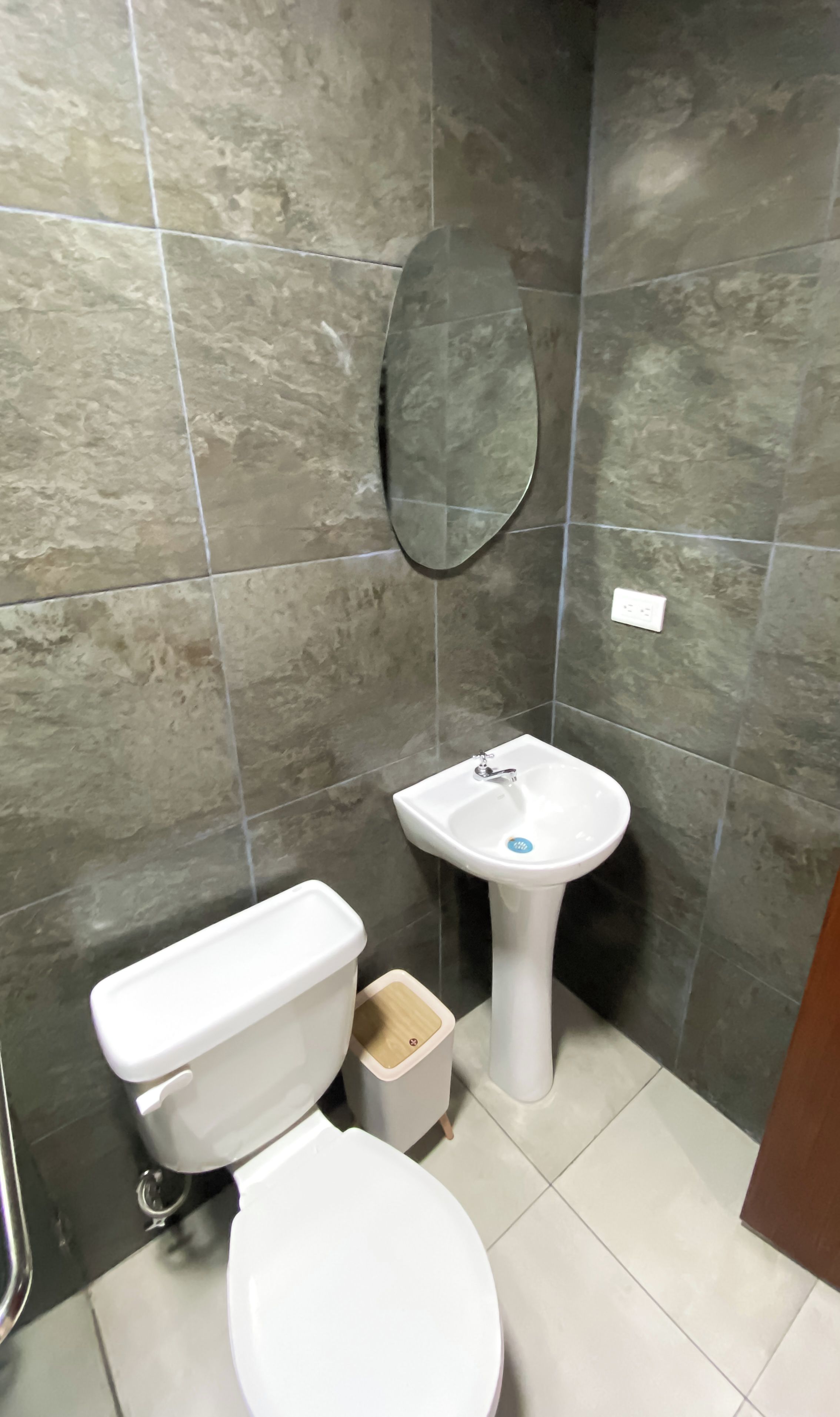 A bathroom with a toilet, sink, and mirror.