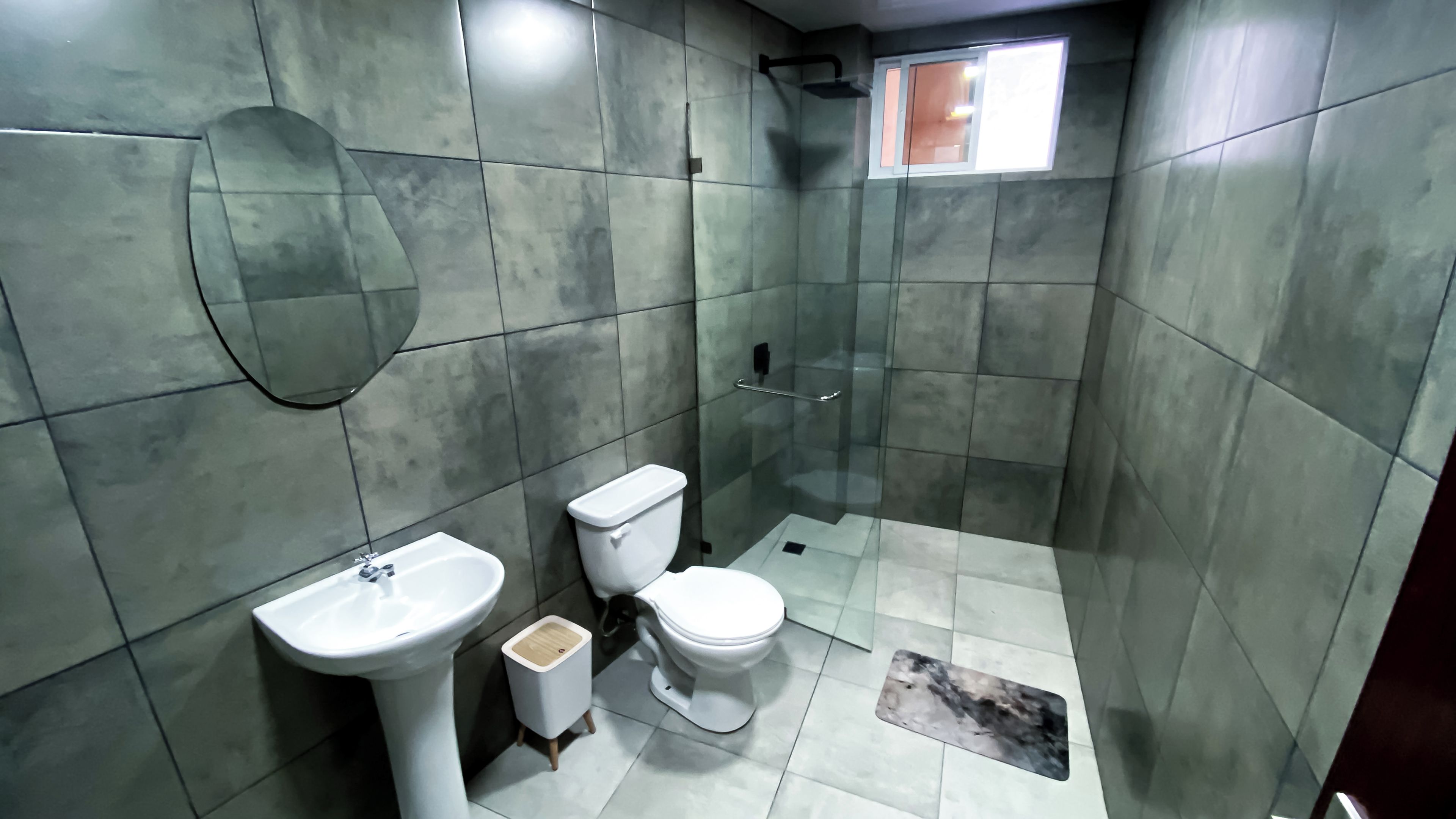 A bathroom with a toilet, sink, and shower area.