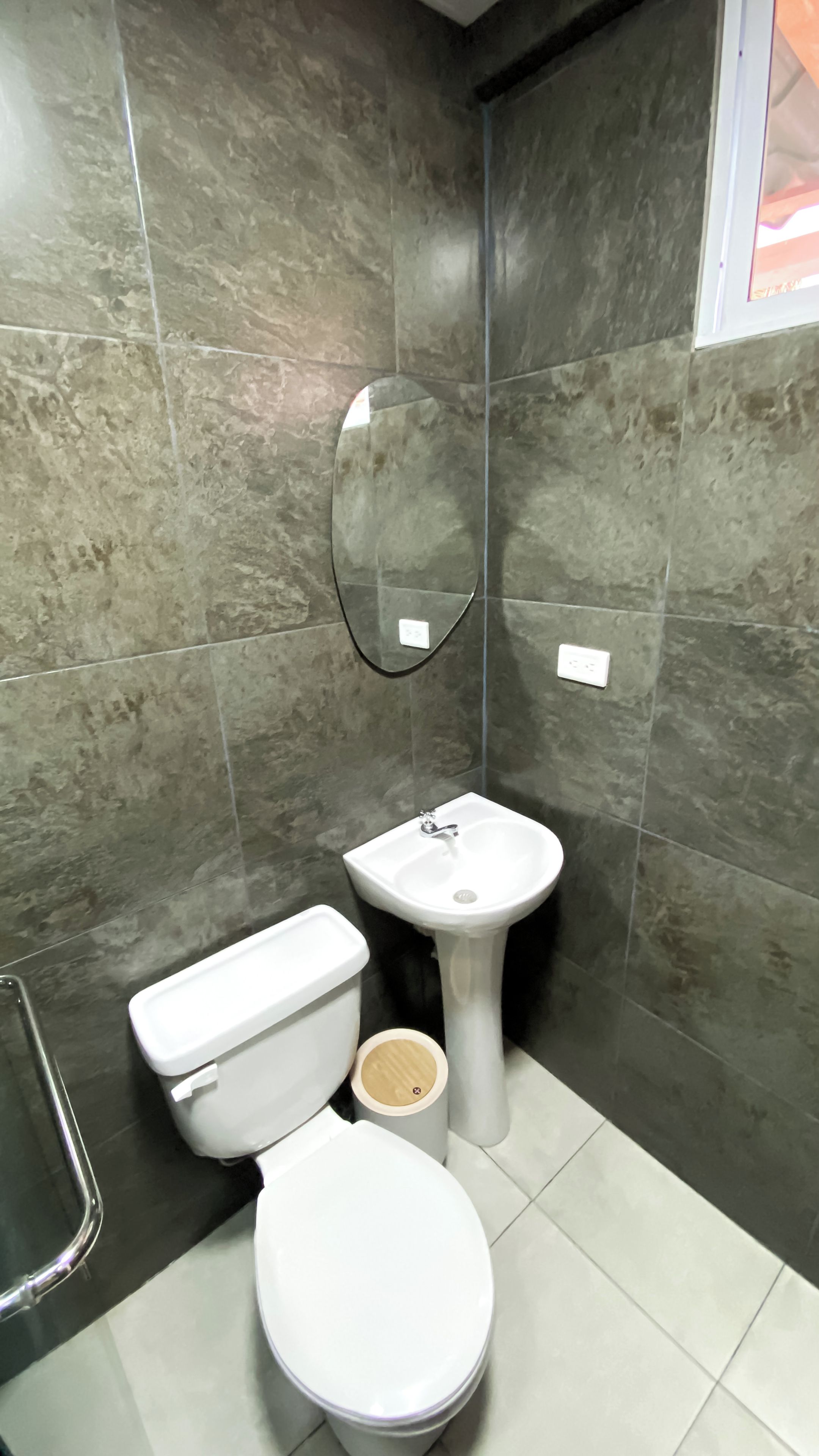 Une salle de bain avec des toilettes, un lavabo et un miroir.
