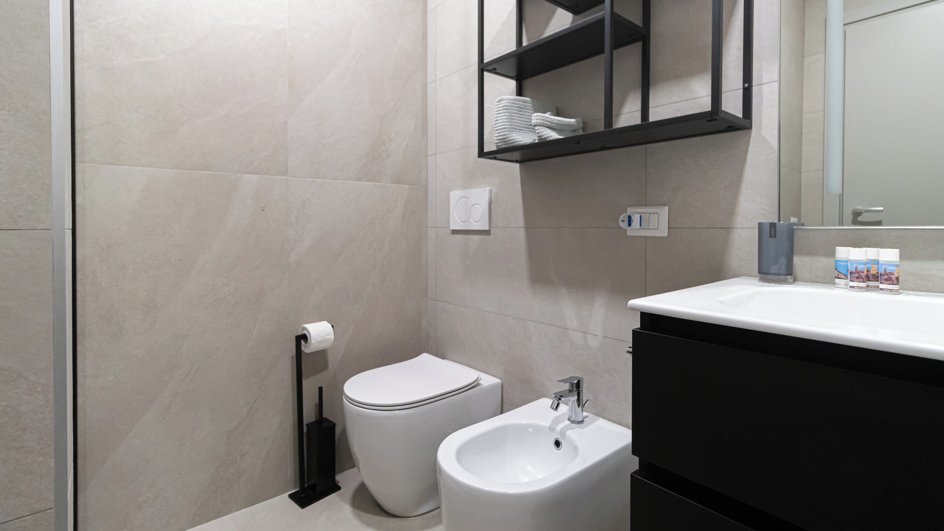 Une salle de bain moderne équipée de toilettes, d’un bidet et d’un lavabo.